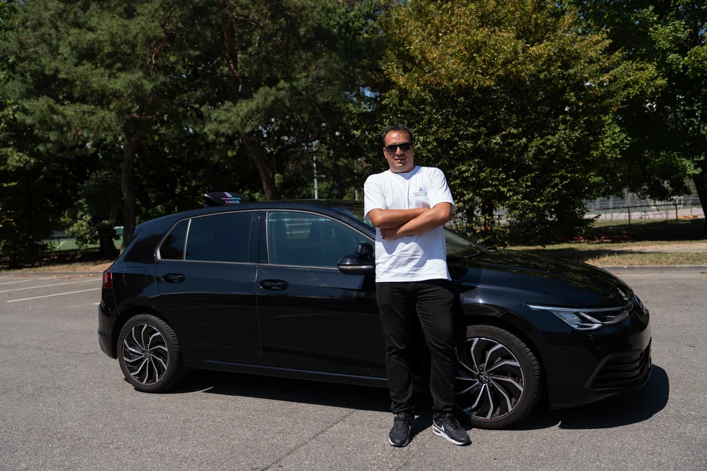 Moniteur de conduite Success Driving School à côté de son véhicule d’auto-école